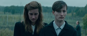 Movie still from “Out Stealing Horses” (2019), directed by Hans Petter Moland – A couple of people standing next to each other in a field; Close Up shot, Over the shoulder angle