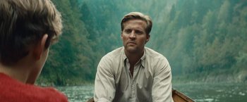 Movie still from “Out Stealing Horses” (2019), directed by Hans Petter Moland – A man sitting in a boat on top of a body of water; Close Up shot, Over the shoulder angle