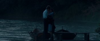 Movie still from “Out Stealing Horses” (2019), directed by Hans Petter Moland – A man and a woman kissing in front of a body of water; Medium shot, Over the shoulder angle