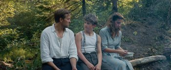 Movie still from “Out Stealing Horses” (2019), directed by Hans Petter Moland – A man and a woman sitting next to a young boy; Medium shot, Over the shoulder angle