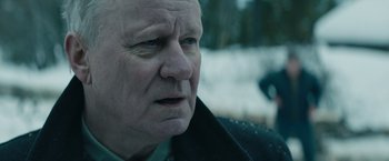 Movie still from “Out Stealing Horses” (2019), directed by Hans Petter Moland – An old man with a beard is looking at the camera; Close Up shot, Over the shoulder angle