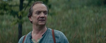 Movie still from “Out Stealing Horses” (2019), directed by Hans Petter Moland – A person wearing a shirt; Close Up shot, Low angle