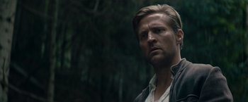 Movie still from “Out Stealing Horses” (2019), directed by Hans Petter Moland – A person wearing a jacket near a forest; Close Up shot, Low angle