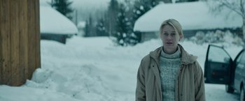 Movie still from “Out Stealing Horses” (2019), directed by Hans Petter Moland – A woman standing in the middle of a snow covered field; Medium shot, Over the shoulder angle