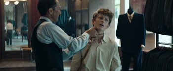 Movie still from “Out Stealing Horses” (2019), directed by Hans Petter Moland – A young man getting help tying a tie; Medium shot, Over the shoulder angle