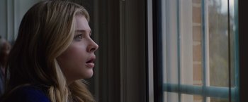 Movie still from “The 5th Wave” (2016), directed by J Blakeson – A beautiful young lady looking out of a window; Close Up shot, Low angle