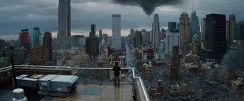 Movie still from “The 5th Wave” (2016), directed by J Blakeson – A man standing on a balcony overlooking a city; Extreme Wide shot, High angle