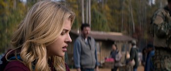 Movie still from “The 5th Wave” (2016), directed by J Blakeson – A woman is looking to her left while a man and woman look on; Close Up shot, Over the shoulder angle