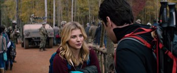 Movie still from “The 5th Wave” (2016), directed by J Blakeson – A woman is talking to a man in the woods; Medium shot, Over the shoulder angle