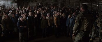 Movie still from “The 5th Wave” (2016), directed by J Blakeson – A large group of people gathered together in a building; Wide shot, High angle