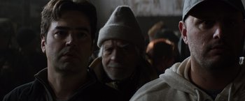 Movie still from “The 5th Wave” (2016), directed by J Blakeson – An old man wearing a gray hat and a white beard; Close Up shot, Over the shoulder angle