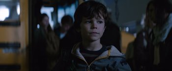 Movie still from “The 5th Wave” (2016), directed by J Blakeson – A young boy is standing in the dark; Close Up shot, Over the shoulder angle