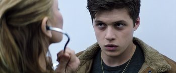 Movie still from “The 5th Wave” (2016), directed by J Blakeson – A young man looking at a young woman with a cell phone in his hand; Close Up shot, Over the shoulder angle