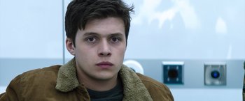 Movie still from “The 5th Wave” (2016), directed by J Blakeson – A young man in a brown jacket looking at the camera; Close Up shot, Low angle