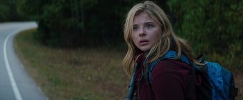 Movie still from “The 5th Wave” (2016), directed by J Blakeson – A young blonde haired girl in a field; Close Up shot, Low angle