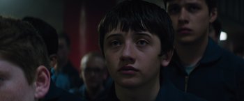 Movie still from “The 5th Wave” (2016), directed by J Blakeson – A young man with a black shirt and black hair; Close Up shot, Low angle