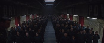 Movie still from “The 5th Wave” (2016), directed by J Blakeson – A large group of people standing in a hallway; Extreme Wide shot, High angle