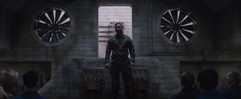 Movie still from “The 5th Wave” (2016), directed by J Blakeson – A man standing in front of a brick wall; Wide shot, Low angle