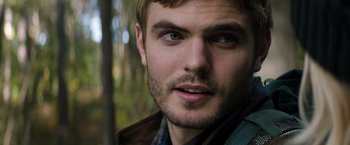 Movie still from “The 5th Wave” (2016), directed by J Blakeson – A man's face with trees in the background; Close Up shot, Over the shoulder angle