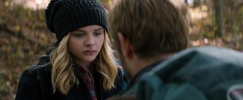 Movie still from “The 5th Wave” (2016), directed by J Blakeson – A young woman wearing a hat and a jacket talking to a young man; Close Up shot, Over the shoulder angle