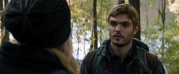 Movie still from “The 5th Wave” (2016), directed by J Blakeson – A man and a woman talking in the woods; Close Up shot, Over the shoulder angle