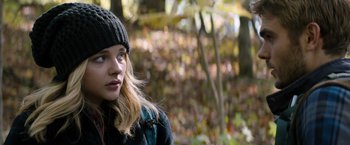 Movie still from “The 5th Wave” (2016), directed by J Blakeson – A woman in a hat and jacket in the woods; Close Up shot, Low angle