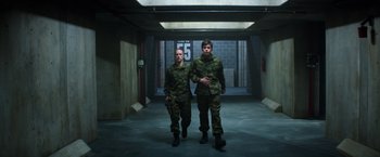 Movie still from “The 5th Wave” (2016), directed by J Blakeson – A couple of men walking down a hall way; Wide shot, Low angle
