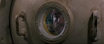 Movie still from “The Abyss” (1989), directed by James Cameron – A man looking into a porthole of a ship; Close Up shot, Low angle