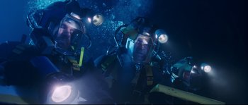 Movie still from “The Abyss” (1989), directed by James Cameron – A group of people in scuba gear in the water; Medium shot, Overhead angle