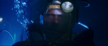 Movie still from “The Abyss” (1989), directed by James Cameron – A man wearing a helmet with a light on his head; Close Up shot, Low angle