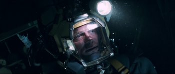 Movie still from “The Abyss” (1989), directed by James Cameron – A person wearing a space helmet; Close Up shot, Overhead angle