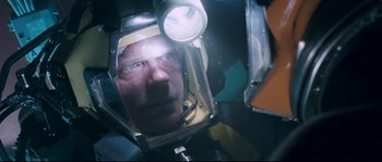 Movie still from “The Abyss” (1989), directed by James Cameron – A man wearing a helmet with a light on his head; Close Up shot, Overhead angle