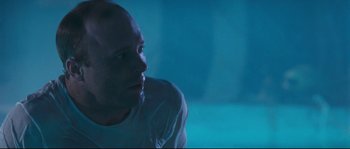 Movie still from “The Abyss” (1989), directed by James Cameron – A man sitting in the middle of a room; Close Up shot, Low angle