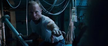 Movie still from “The Abyss” (1989), directed by James Cameron – A man in white shirt and blue jeans holding out his hand; Medium shot, Overhead angle
