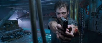 Movie still from “The Abyss” (1989), directed by James Cameron – A man holding a gun in his hand; Close Up shot, Low angle