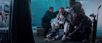 Movie still from “The Abyss” (1989), directed by James Cameron – Two men in spacesuits are sitting on the ground; Medium shot, High angle
