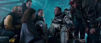 Movie still from “The Abyss” (1989), directed by James Cameron – A group of people standing next to each other; Medium shot, Over the shoulder angle