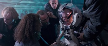 Movie still from “The Abyss” (1989), directed by James Cameron – A group of people standing next to each other in a room; Medium shot, High angle