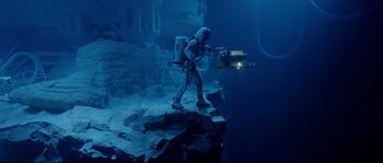 Movie still from “The Abyss” (1989), directed by James Cameron – A man in a diving suit is holding a device in his hand; Extreme Wide shot, High angle
