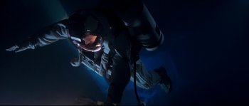 Movie still from “The Abyss” (1989), directed by James Cameron – A man in a scuba suit and a helmet is in the dark; Wide shot, Overhead angle
