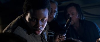 Movie still from “The Abyss” (1989), directed by James Cameron – A man holding a cell phone in a dark room; Close Up shot, Over the shoulder angle