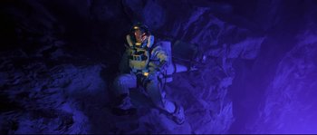 Movie still from “The Abyss” (1989), directed by James Cameron – A man sitting on the ground wearing a space suit; Wide shot, Overhead angle