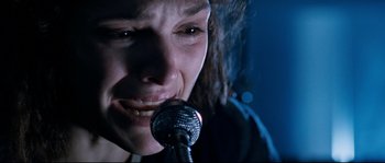 Movie still from “The Abyss” (1989), directed by James Cameron – A woman is crying while holding a microphone; Extreme Close Up shot, Low angle