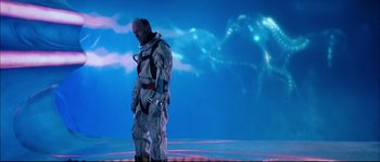 Movie still from “The Abyss” (1989), directed by James Cameron – A man in a spacesuit standing in front of a blue sky; Wide shot, Low angle