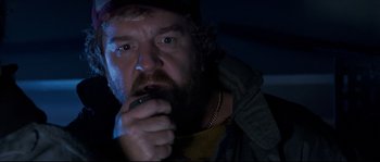 Movie still from “The Abyss” (1989), directed by James Cameron – A man with a beard is holding a cell phone; Close Up shot, Low angle