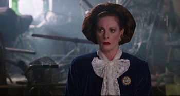 Movie still from “The Addams Family” (1991), directed by Barry Sonnenfeld – An older woman wearing a blue jacket and a white lace collar; Close Up shot, Low angle