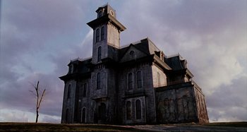 Movie still from “The Addams Family” (1991), directed by Barry Sonnenfeld – An old building with a clock on the top of it; Extreme Wide shot, Low angle