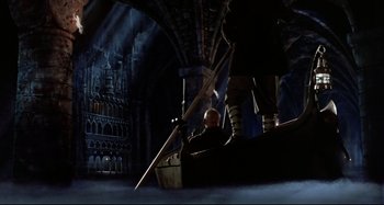Movie still from “The Addams Family” (1991), directed by Barry Sonnenfeld – A scene of a boat in the middle of a dark room; Wide shot, High angle