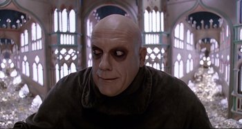 Movie still from “The Addams Family” (1991), directed by Barry Sonnenfeld – A man with a bald head wearing a black jacket; Close Up shot, Low angle