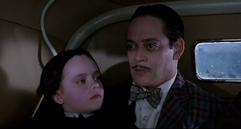 Movie still from “The Addams Family” (1991), directed by Barry Sonnenfeld – A man and a child in a car; Close Up shot, High angle